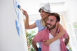 © didesign - Young couple painting walls and having fun at new home