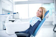 © didesign - Smiling and satisfied patient in a dental office