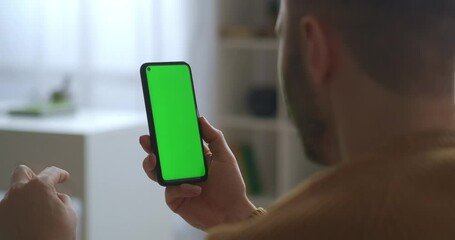 communication by app in smartphone, video call on green screen, man is talking and looking on display, closeup