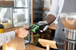 © Vadim Pastuh - Close-up picture female customer making contactless payment with a credit card, a hand of waiter holds a terminal. Protective measures during quarantine lockdown period