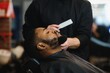 © Serhii - Young African-american man visiting barbershop