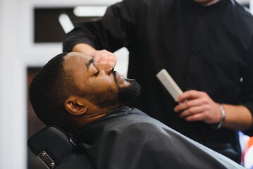 black man in the barbershop. cute black man makes a haircut in the african salon. hair style. haircu