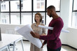 © WavebreakMediaMicro - Diverse male and female colleague looking at blueprints and discussing
