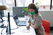 © WavebreakMediaMicro - Asian businesswoman wearing face mask sitting at desk looking at samples in creative office