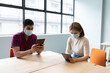 © WavebreakMediaMicro - Diverse male and female business colleague wearing face masks using tablets