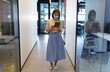 © WavebreakMediaMicro - Asian businesswoman wearing face mask standing in corridor using tablet