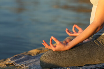 Wall Mural - Woman hands at sunset practicing yoga on the beach