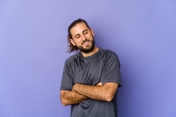 Wall Mural - Young man with long hair look points with thumb finger away, laughing and carefree.