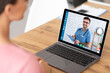 © Prostock-studio - Medical care during quarantine. Unrecognizable woman speaking to friendly young doctor online from home
