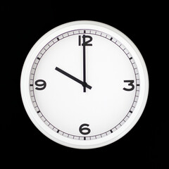 Wall Mural - White round analog wall clock isolated on black background.