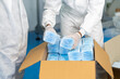 © NVB Stocker - Workers are packing masks in boxes for delivery to customers. industry factory and people concept. indoors