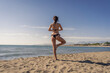 © Vladimir Borovic - Beautiful young female doing yoga on beach. Gorgeous woman in bikini meditating on beach at summertime on vacation