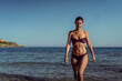 © Vladimir Borovic - Beautiful young woman in bikini on vacation swimming in sea and enjoying in sand beach. Happy female enjoying summer time holiday on beach.