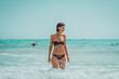 © Vladimir Borovic - Beautiful young woman in bikini on vacation swimming in sea and enjoying in sand beach. Happy female enjoying summer time holiday on beach.