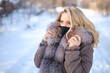 © Roman - beautiful blonde with a fur collar in a black protective mask in the winter in the park