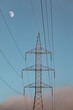 © Nue - Torre eléctrica en medio de la naturaleza en un día despejado en el que se puede ver la luna