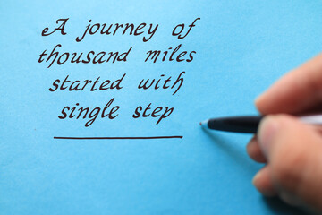 journey of thousand miles started with single step, text words typography written on blue background