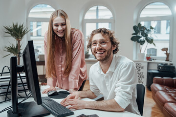 Portrait of a happy male and female partners having a good time and doing their collaboration in office room.