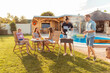 © Impact Photography - Friends grilling meat and having fun at backyard poolside barbecue party