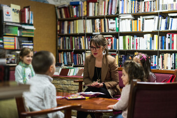 Teacher talks to kids in library about books