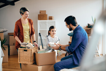 Wall Mural - Happy family unpacking their belongings while moving into a new home.