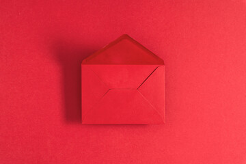 Red open empty envelope on red background. Red background with envelope. Flat lay, top view, copy space