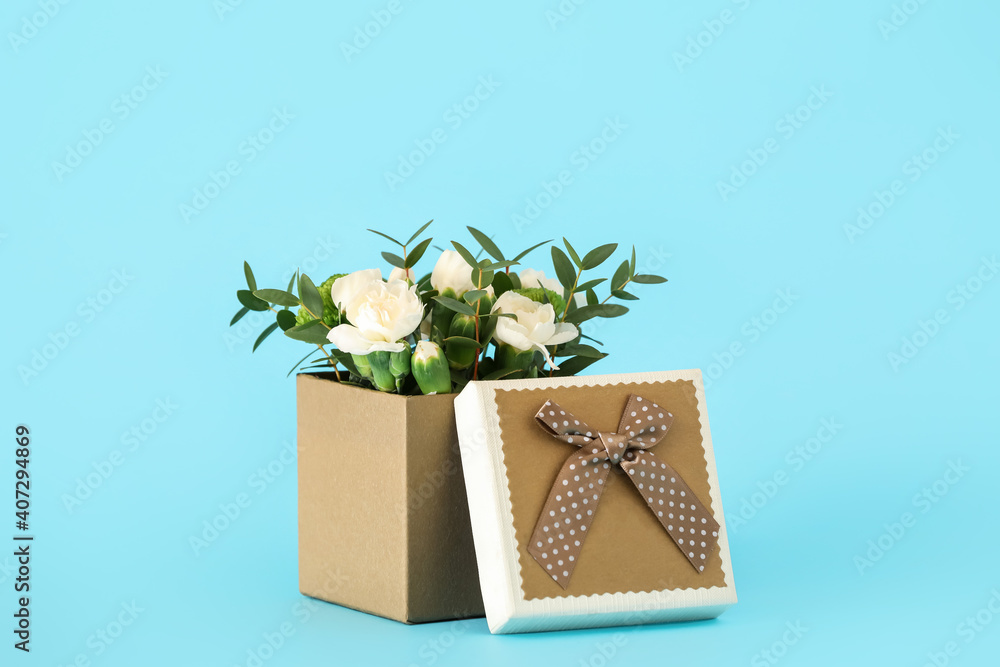 Gift box with beautiful flowers on color background