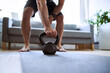 © baranq - Closeup of man grabing kettlebell during home workout exercises