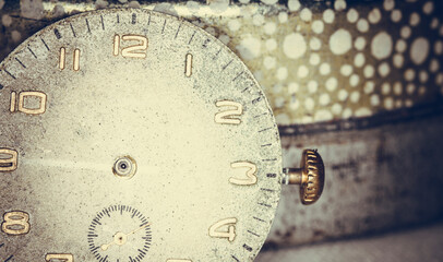 Vintage grunge background of an old clock. Abstract texture covered with dust, dirt, scratches. Macro photography in light tinted