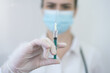 © as-artmedia - COVID-19 vaccine in researcher hands, female doctor holds syringe with vaccine for coronavirus cure. Concept of corona virus treatment, injection, shot and clinical trial during pandemic.