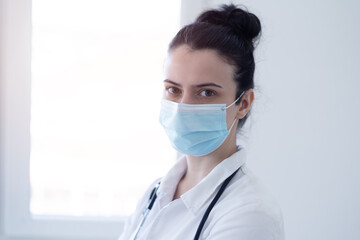 COVID-19 concept Female doctor wearing protective mask and looking into camera  during pandemic.