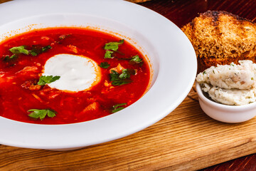 Wall Mural - Traditional Ukrainian Russian borscht or beetroot red soup with sour cream in white plate