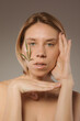 © olgalisa88 - CBD cosmetics concept. Beautiful woman with a cannabis leaf on gray background