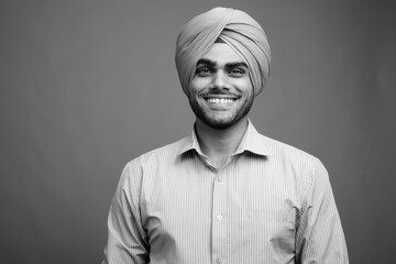 Wall Mural - Young handsome Indian Sikh businessman wearing turban