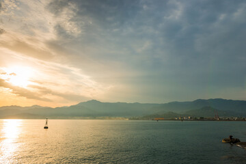 Wall Mural - Buoy - a small lighthouse in the sea in the setting sun