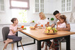 © New Africa - Happy family having breakfast together at table in modern kitchen