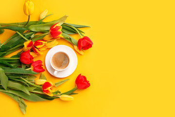 Wall Mural - Beautiful spring breakfast on Mothers or Womans International day 8 march. Bouquet of red yellow tulips and coffee cup on bright yellow table top view. Flat lay, banner for site, seasonal flyer