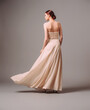 Elegant backless moscato dress. Beautiful pink chiffon evening gown. Studio portrait of young ginger woman. Transformer dress idea for an event. Bridesmaid dresses.