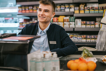 Wall Mural - Man working at a supermarket checkout counter