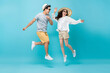 © Atstock Productions - Smiling energetic Asian couple tourists in summer beach casual clothes jumping isolated on light blue studio background