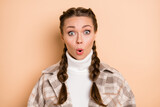 Photo of young beautiful pretty attractive shocked amazed surprised girl with braids isolated on beige color background