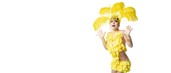 Wall Mural - Astonished. Beautiful young woman in carnival masquerade costume with yellow feathers dancing on white background. Concept of holidays celebration, festive time, dance, party, happiness. Flyer