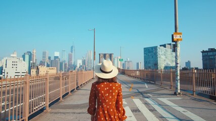 Wall Mural - Attractive girl walking across the Brooklyn Bridge in New York