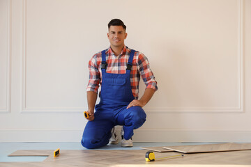 Canvas Print - Professional worker installing new parquet flooring indoors