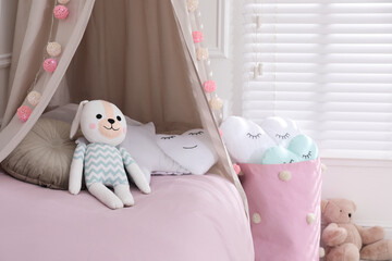 Wall Mural - Cute toy bunny on bed in stylish playroom. Interior design