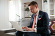 © JustLife - Young businessman working with laptop at office. Businessman sitting on sofa having video call