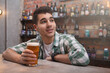 © Ihor - Happy handsome young man enjoying beer at the pub, copy space