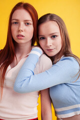 lifestyle people concept: two pretty young school teenage girls having fun happy smiling on yellow background