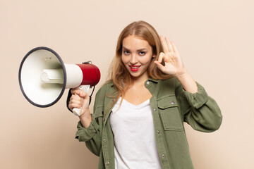 Wall Mural - blonde woman feeling happy, relaxed and satisfied, showing approval with okay gesture, smiling