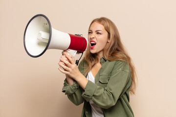 Wall Mural - blonde woman feeling happy, excited and positive, giving a big shout out with hands next to mouth, calling out